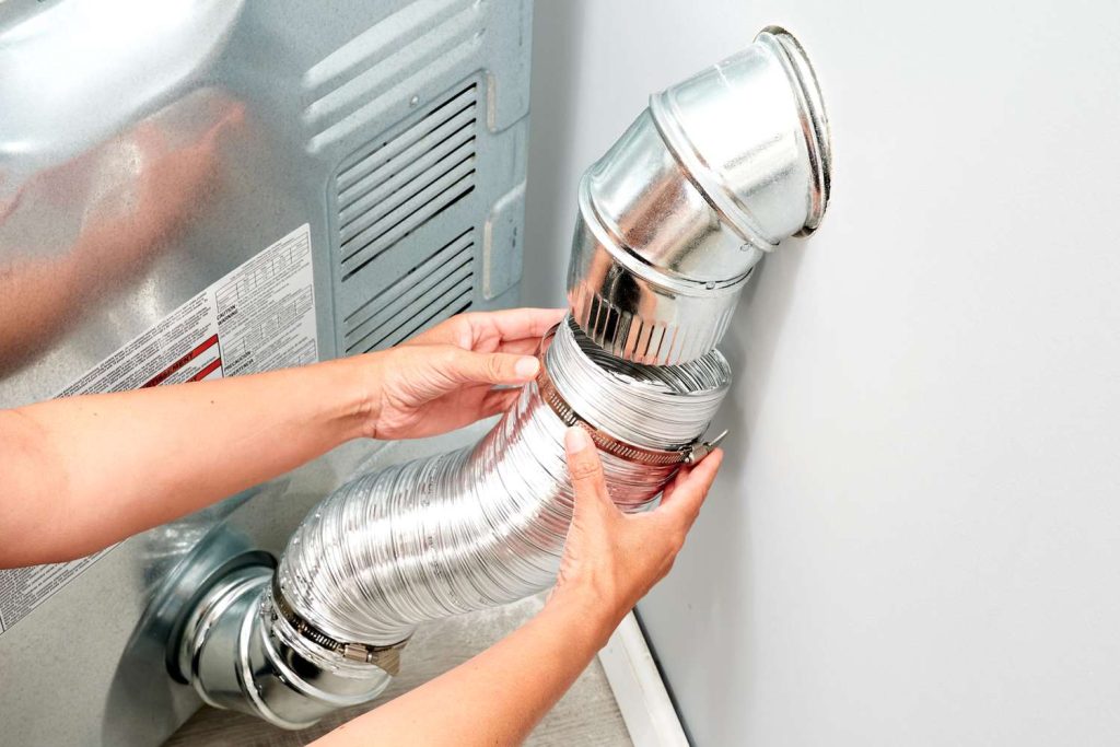Technician installing a residential dryer vent in Dallas-Fort Worth